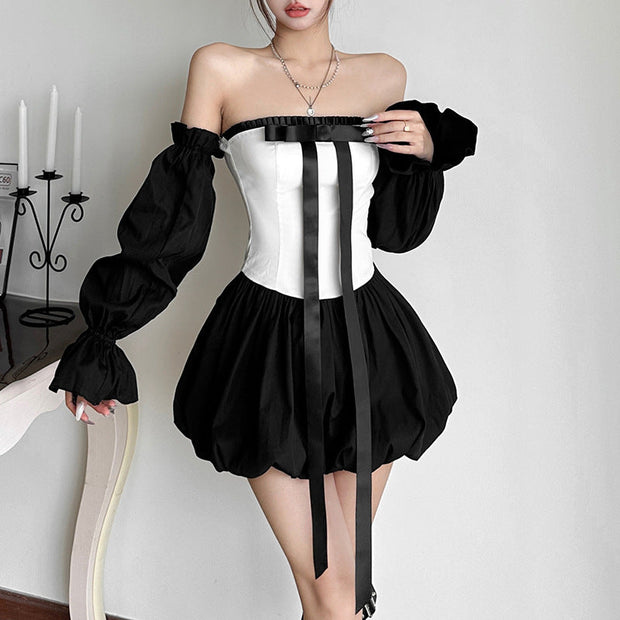 Woman wearing Bow Tique black and white off-shoulder bud skirt with bow detail and puff sleeves