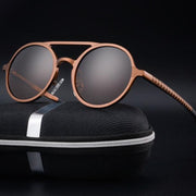 Round sunglasses with durable, lightweight lens material and UV400 protection on a black case.